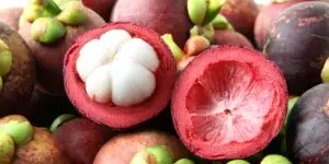 Čerstvý mangostan v košíku, s jedným plodom rozrezaným na polovicu, odhaľujúcim bielu dužinu